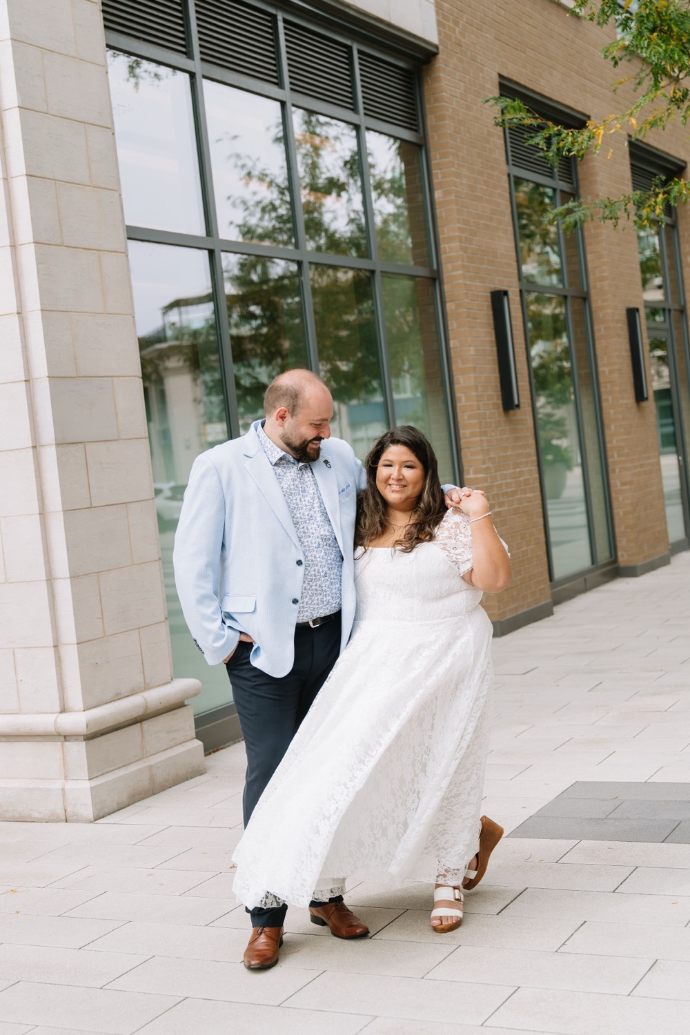 Angela and Michael laughing as they walk past a stone building