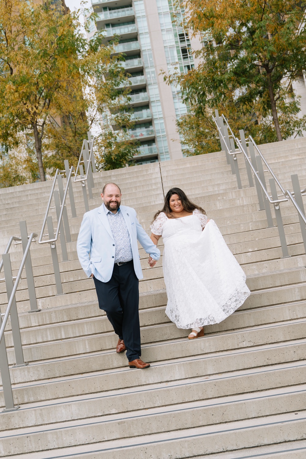 Angela and Michael walking down wide stone steps hand in hand