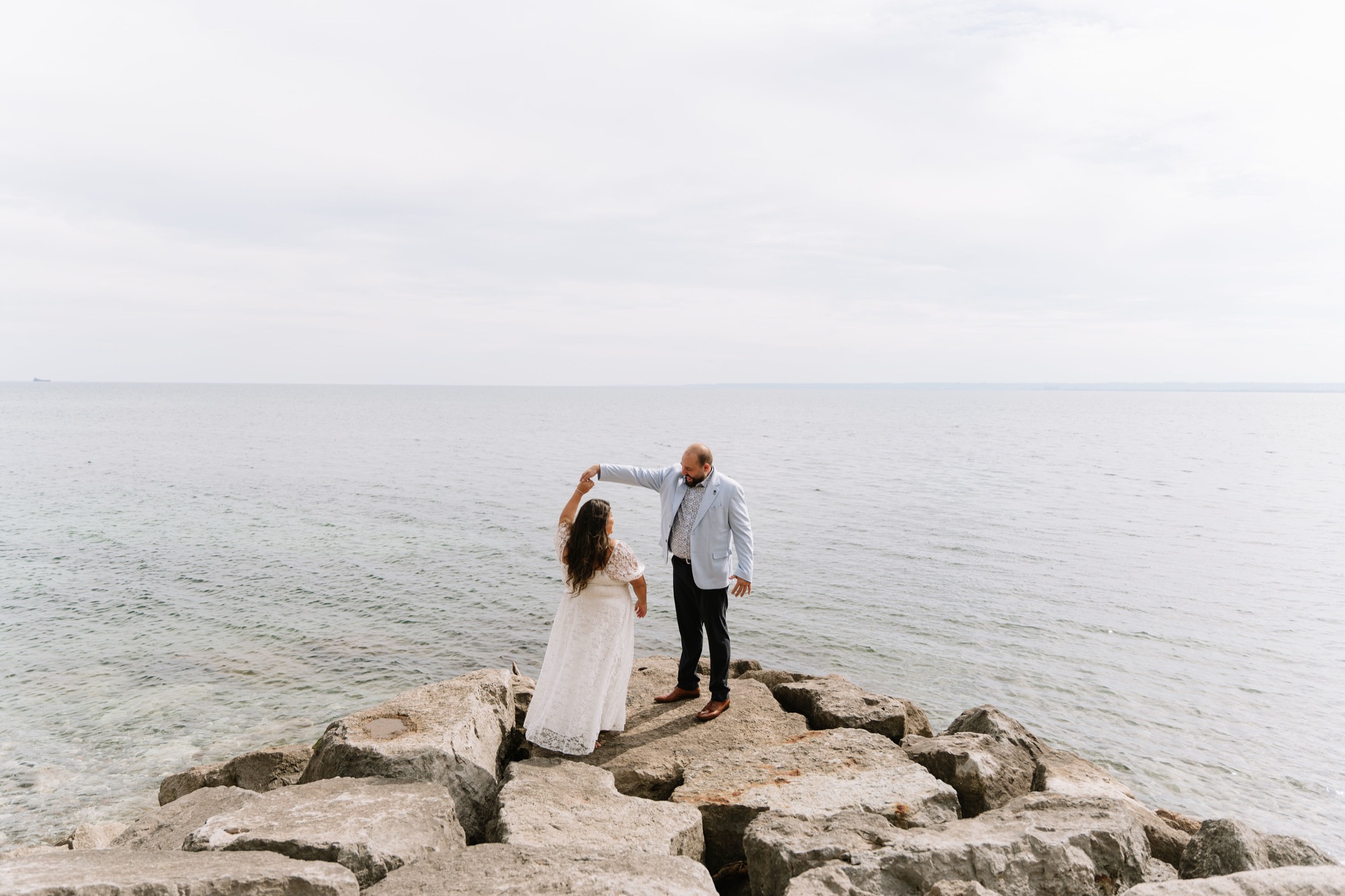 Michael twirling Angela on the rocks at the edge of the lake